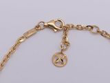 a close up of a gold chain with a peace sign on it