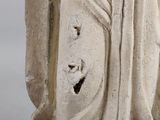 an old statue of a woman holding a bird in her hand