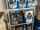 plusieurs cartons d'huile moteur posés sur une étagère dans un garage