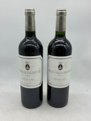 deux bouteilles de vin rouge posées l'une à côté de l'autre sur une surface blanche