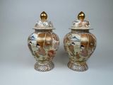 pair of asian vases with gold lids on a white background
