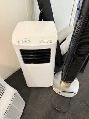 un climatiseur blanc posé à côté d'un climatiseur noir et blanc
