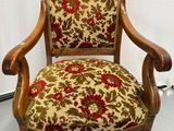 une vieille chaise en bois dont l'assise est recouverte d'un tissu à motifs floraux