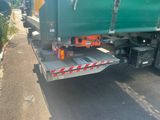 a green truck that is parked on the side of the road