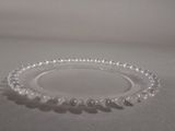 a glass plate with a beaded edge on a table