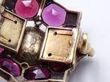 a close up of a ring with pink and purple stones