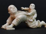 a figurine of a man and a child laying on the ground