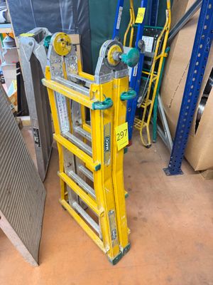une échelle jaune posée à côté d'une pile de cartons