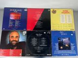 six cd ' s of various music, including a man with a beard, are on a table