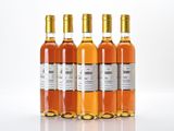 four bottles of wine are lined up on a white surface