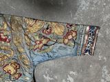 a blue and gold jacket with flowers on it on the ground