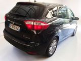 the back end of a black car parked in a white room