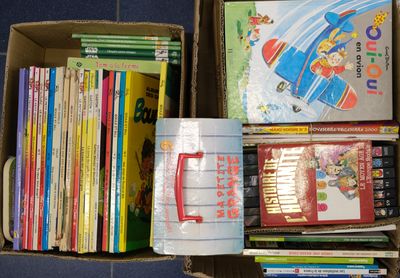 une boîte remplie de livres posés sur le sol