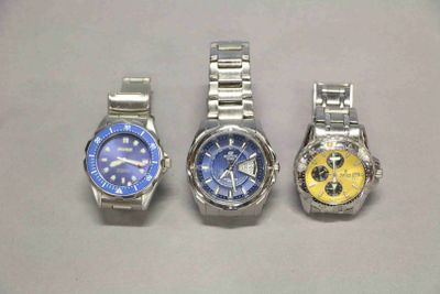 quatre montres sont alignées les unes à côté des autres sur une surface blanche