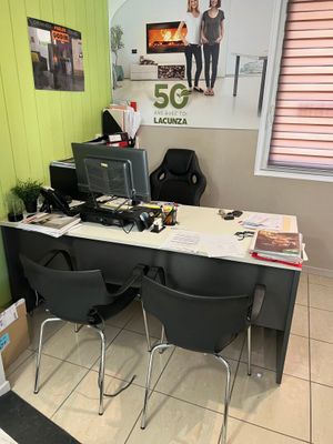 a desk with two chairs and a computer on it