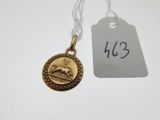 un gros plan d'une pièce d'or sur laquelle est accrochée une étiquette