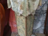 a stone pedestal with a cloth covering it in front of a stone wall