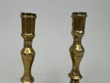 pair of brass candlesticks on a white background