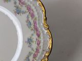 a white plate with a gold rim and purple flowers on it