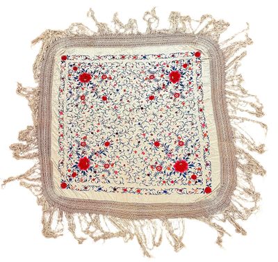 a close up of a white square with red and blue flowers on it