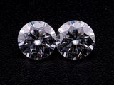 une paire de diamants taille ronde sur un fond noir