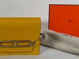 un petit sac à main jaune avec une boucle en argent et un tissu