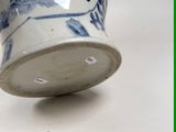 a blue and white vase sitting on a white table