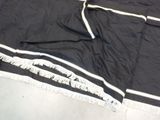 a black and white blanket with white fringes on it