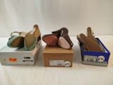 three pairs of women ' s shoes in boxes on a white surface