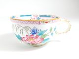 a cup with a floral design on it on a white surface
