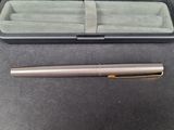 a pen and a box on a table with a pen in it