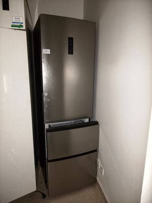 un réfrigérateur dans un coin d'une pièce dont la porte est ouverte