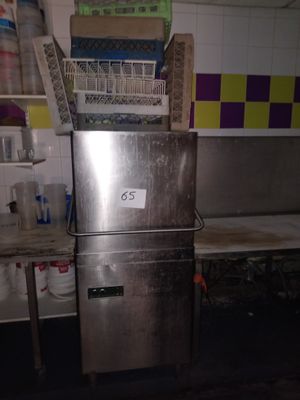 un réfrigérateur argenté au milieu d'une cuisine sale