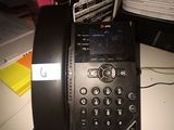 a telephone that is sitting on a desk next to a computer