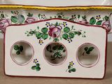 a small vase with three holes in it on a table