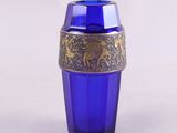 un verre bleu bordé d'or et un verre bleu bordé d'or posé dessus