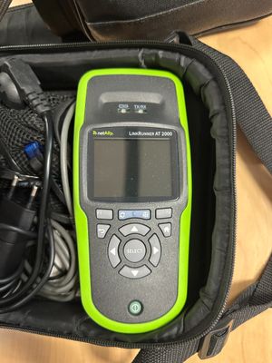 a green and black cell phone in a black bag