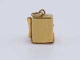 a close up of a small gold piece of jewelry on a white surface