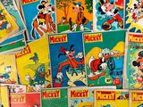 a lot of mickey mouse comic books on the table