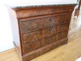 a wooden dresser with a marble top on a hard wood floor
