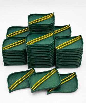 un tas de plateaux verts avec des rayures jaunes