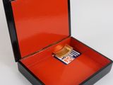 a small box with a cigarette in it on a white surface