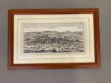 a framed picture of a view of a city in a wood frame
