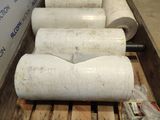 several rolls of paper are lined up on a pallet in a warehouse