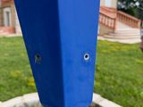 a blue pole with a hole in the middle of it