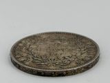 gros plan d'une pièce d'argent sur une surface blanche