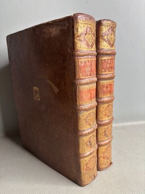 two old books sitting on top of a table next to each other