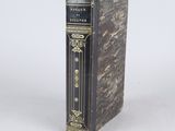 an old book sitting on top of a table next to a white wall
