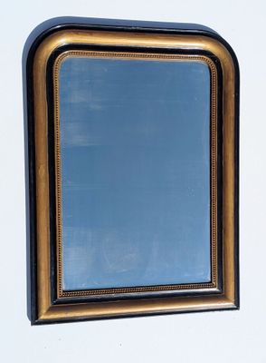 un miroir accroché au mur, avec un ciel bleu en arrière-plan