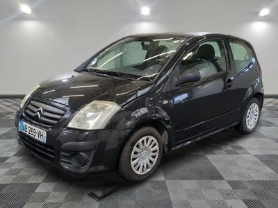la photo d'une petite voiture noire sur un sol en damier